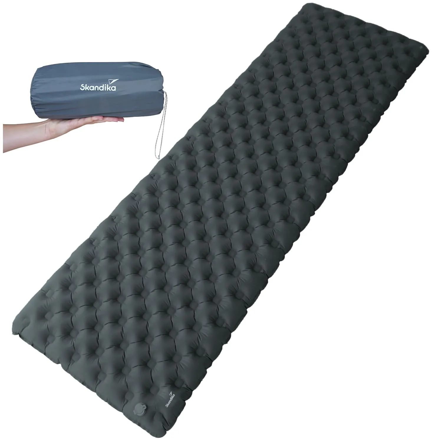 Schlafmatte in dunklem Grau mit gepolstertem Design. Links ist eine zusammengepackte Version in einer Hand sichtbar.