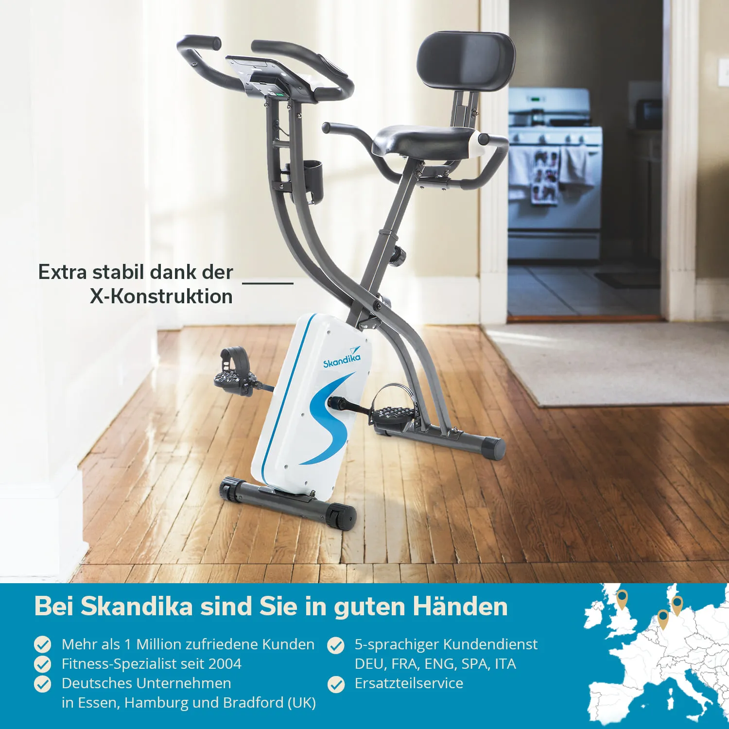 Fahrrad-Ergometer mit X-Konstruktion, montiert auf einem Holzfußboden in einem Raum mit einem Türöffnungsbereich im Hintergrund.