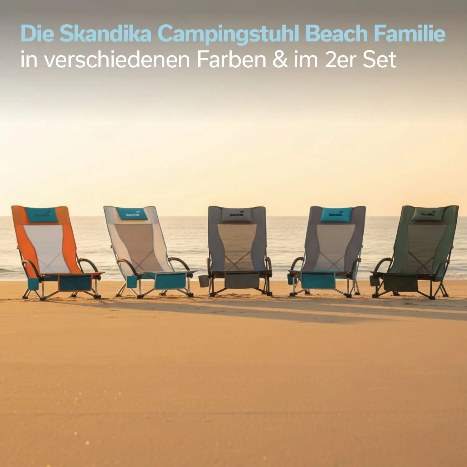 Fünf Campingstühle in unterschiedlichen Farben stehen nebeneinander am Strand. Der Sand und das Meer sind im Hintergrund sichtbar.