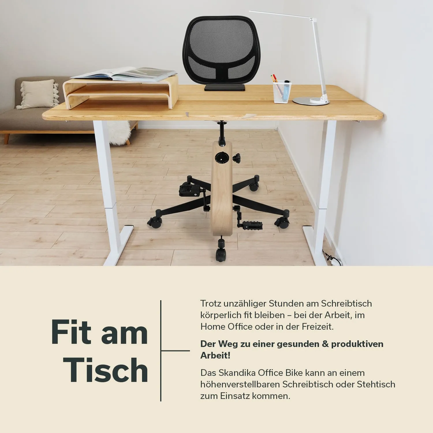 Schreibtisch aus Holz mit einem schwarzen Bürostuhl. Eine Schreibtischlampe und ein Organizer mit Stiften stehen auf dem Tisch. Im Hintergrund ein Sofa.