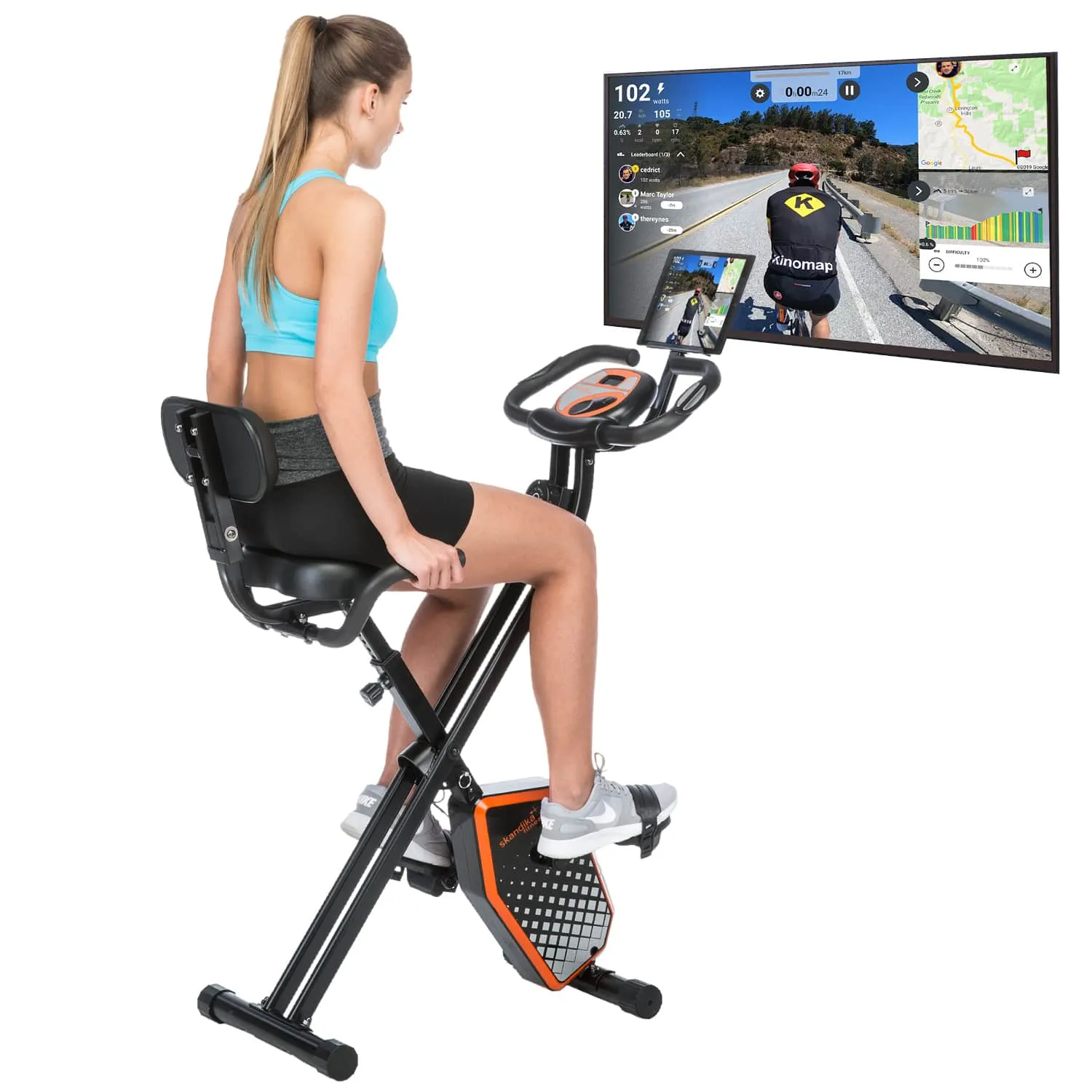 Eine Person sitzt auf einem Indoor-Fahrrad. Vor ihr ist ein Bildschirm mit einer Fahrradtour-Anzeige.