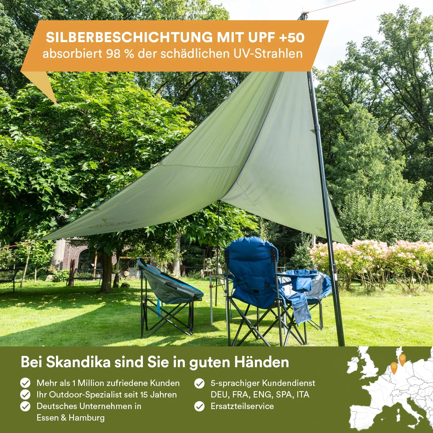Zelt oder Sonnensegel mit Silberbeschichtung steht auf Wiese, darunter zwei faltbare Stühle. Umgeben von Bäumen und Blumen.