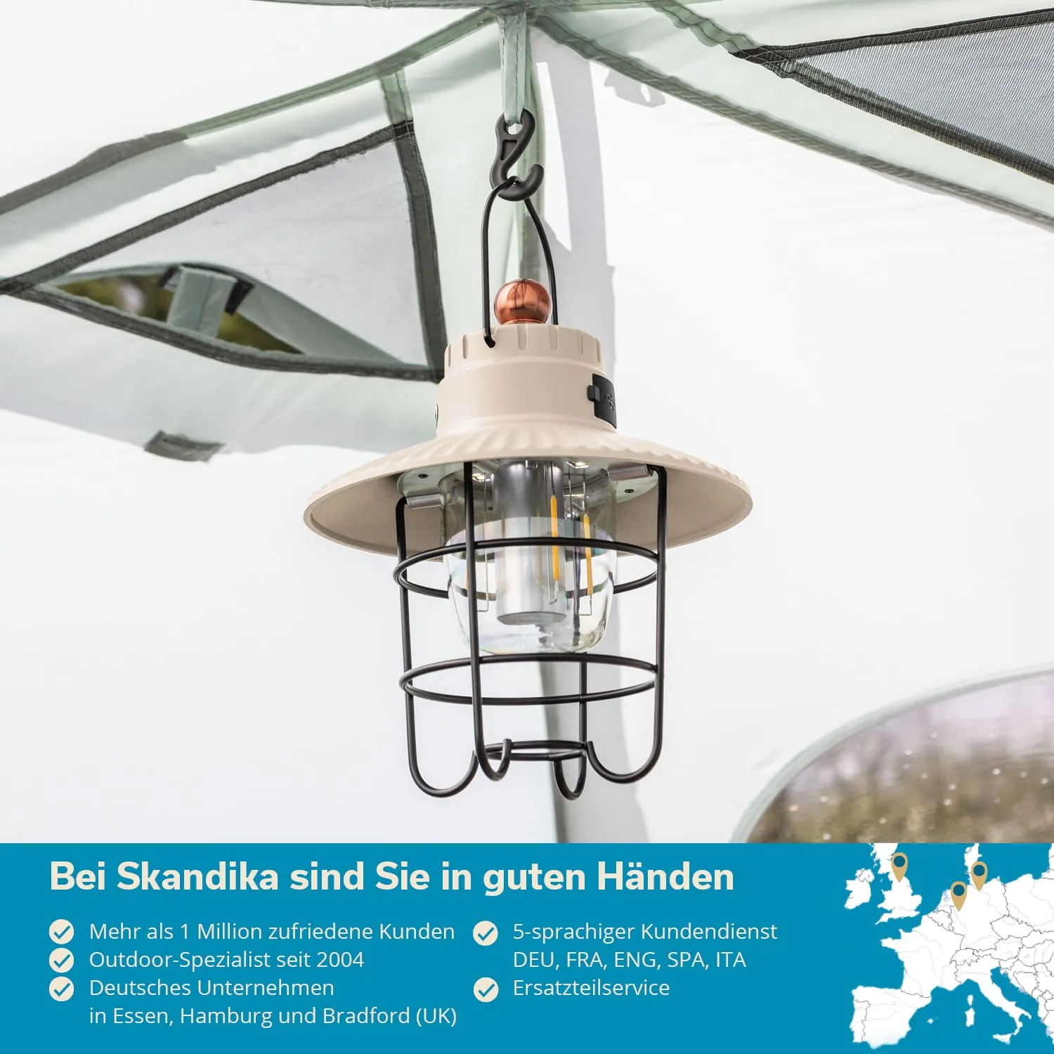 Hängende Lampe mit einem grauen Lampenschirm und einem schützenden Gitter, montiert unter einem Zelt.