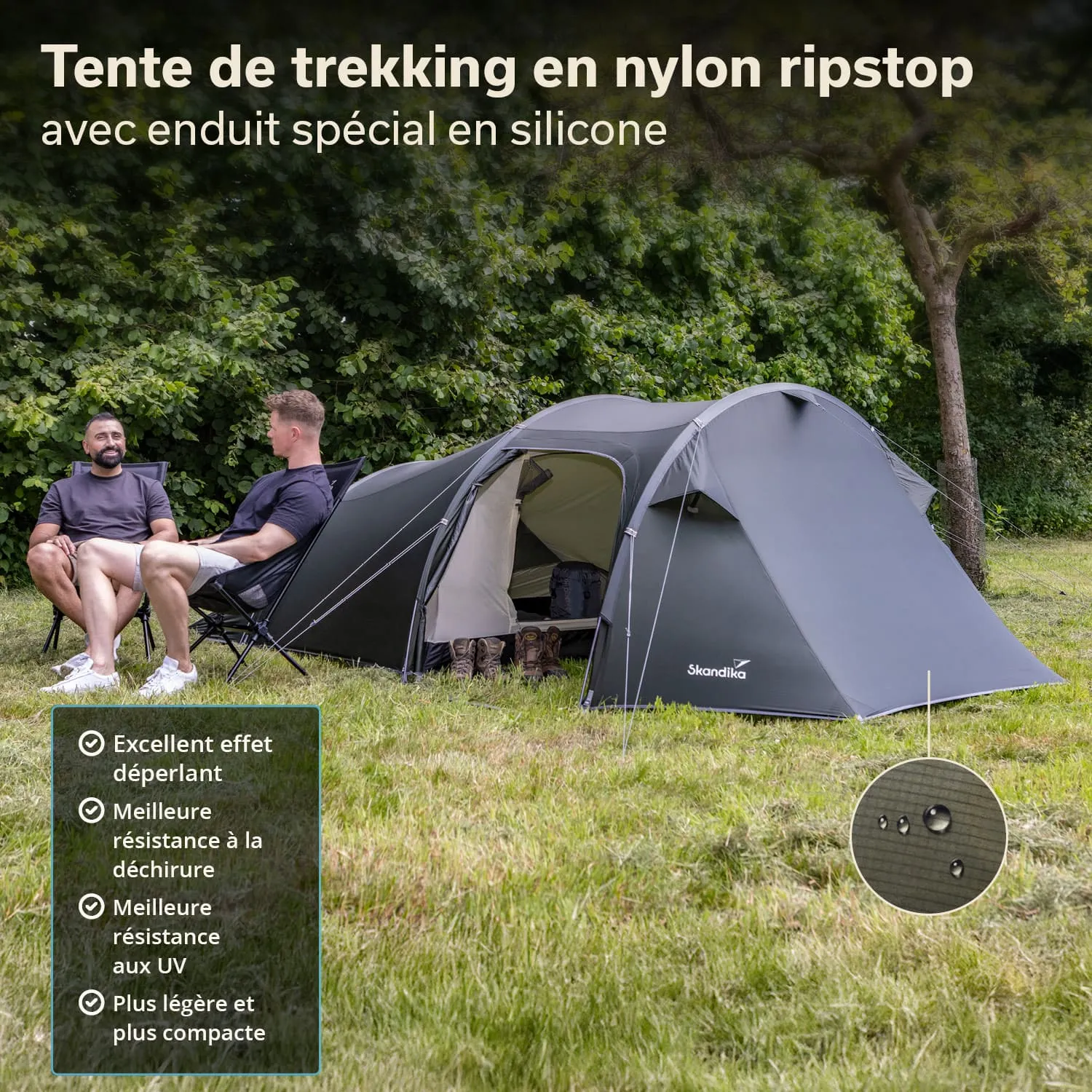 Zelt aus Nylon in einer grünen Umgebung, zwei Personen sitzen auf Stühlen davor, Wanderschuhe stehen am Zelteingang.