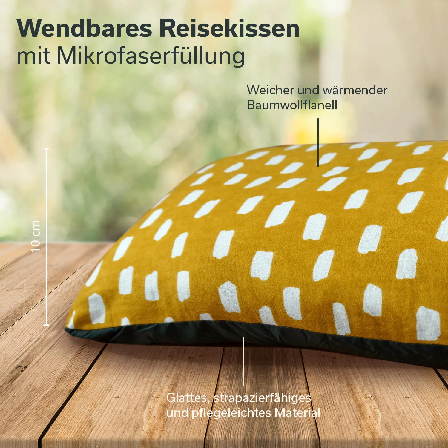 Wendbares Reiseekissen in Gelb mit weißen Mustern auf einer Holztischoberfläche. Kissenhöhe 10 cm.