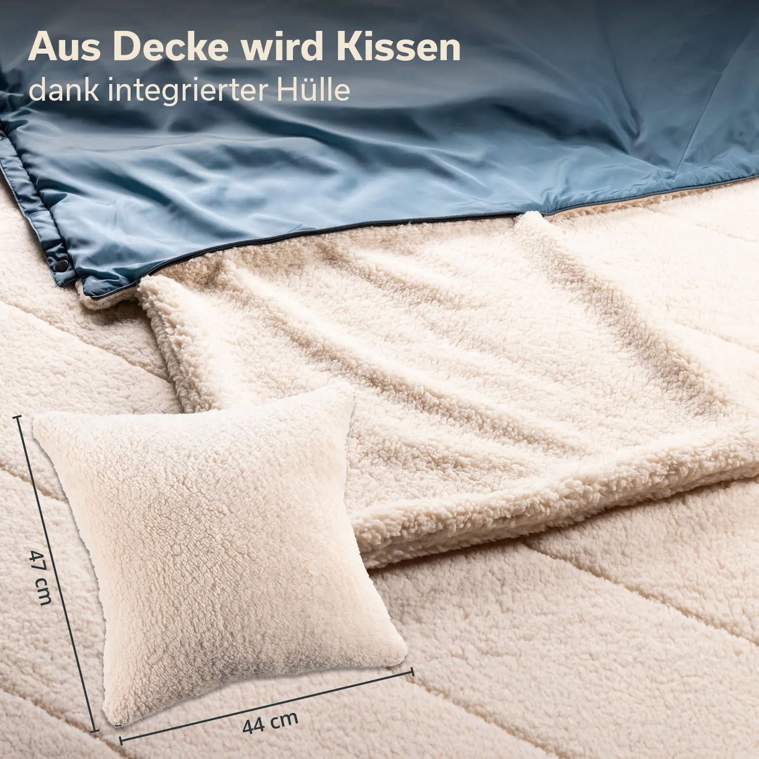 Beige Kuscheldecke und Kissen auf einem Bett, Kissen mit Maßen in cm angezeigt. Decke hat eine glatte Oberseite.