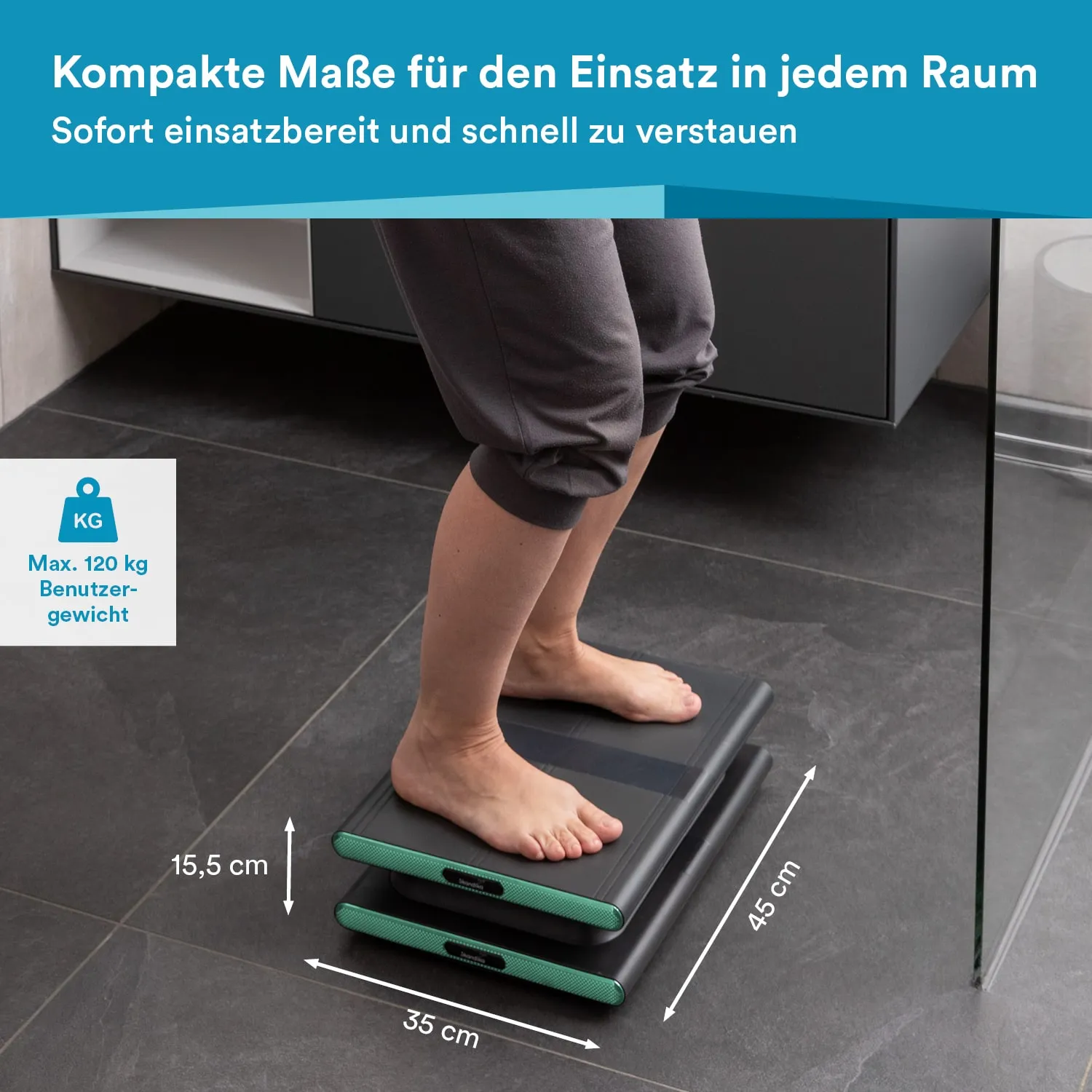 Eine Person steht barfuß auf einer kompakten, grauen Plattform, die auf einem dunklen Boden liegt. Daneben sind Informationen zu den Abmessungen und dem maximalen Benutzergewicht zu sehen.