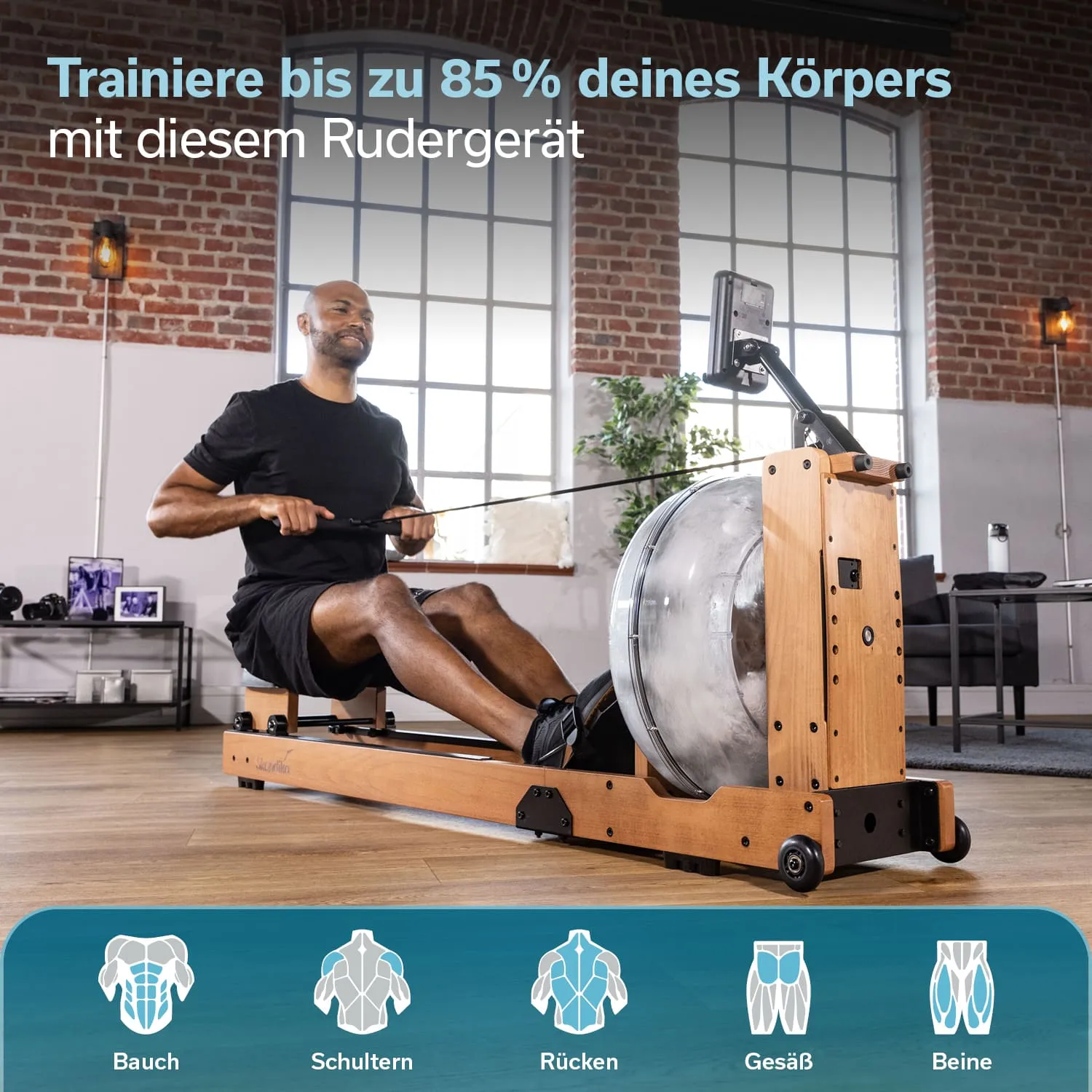 Rudergerät aus Holz mit einer Person, die trainiert. Sie sitzt mit Rudergriff und blickt nach vorne. Helle Fenster im Hintergrund.