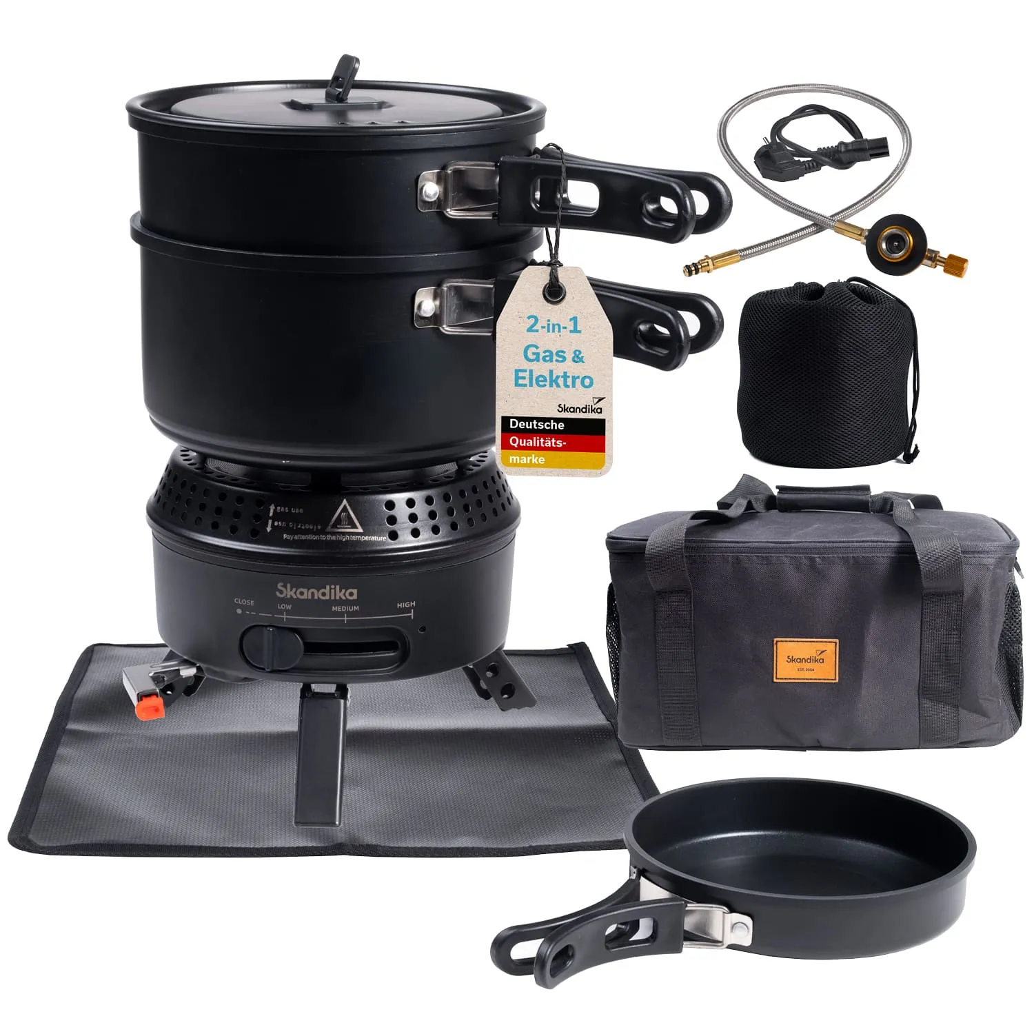 Campingkocher in Schwarz mit zwei Töpfen, einer Pfanne, einem Gasschlauch und einer Tasche. Zubehör auf einer grauen Matte.