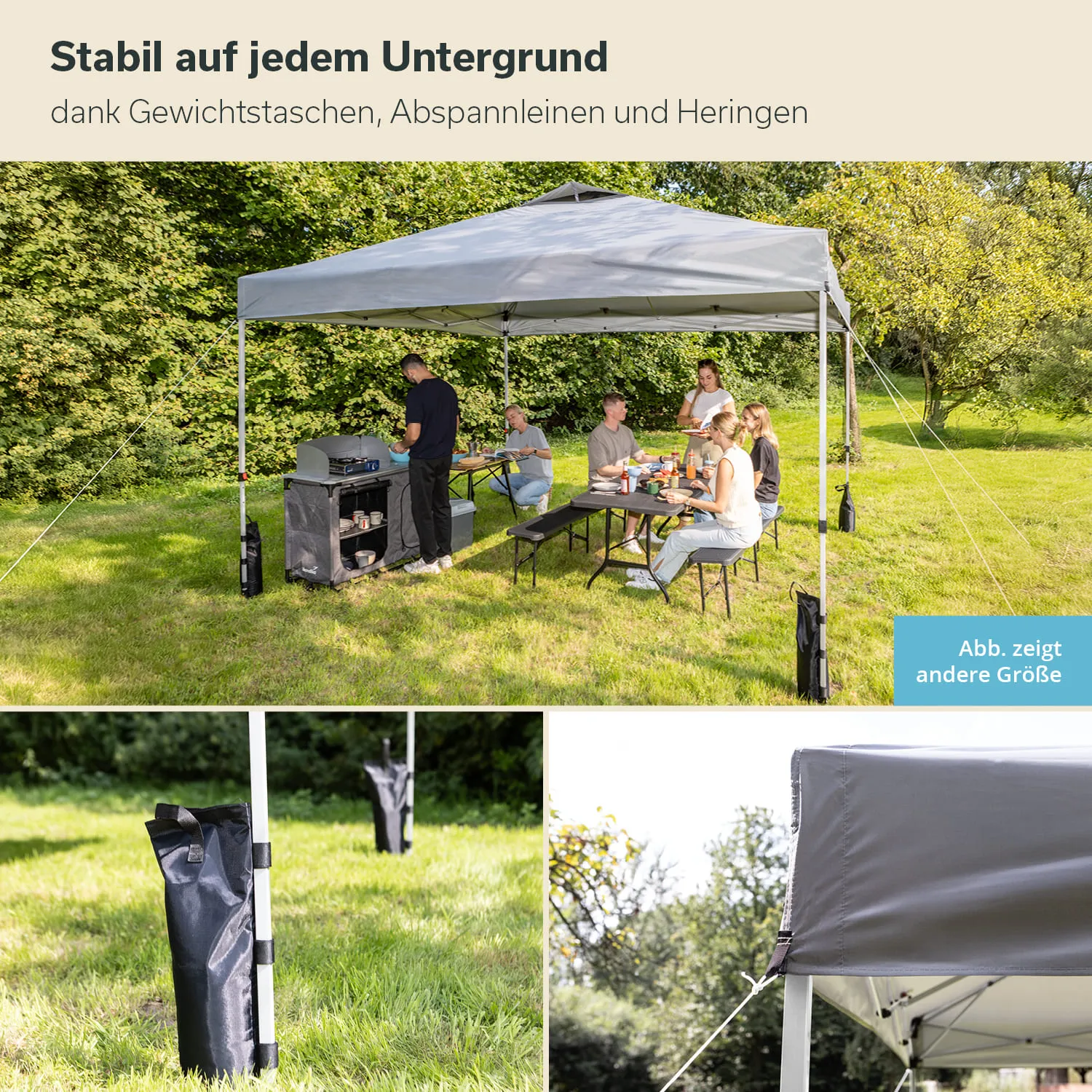 Ein feststehendes Zelt steht auf einem grünen Rasen. Eine Gruppe von Personen sitzt an einem Tisch und isst, während im Hintergrund ein Grill zu sehen ist. Abspannleinen und Gewichtstaschen sind sichtbar.