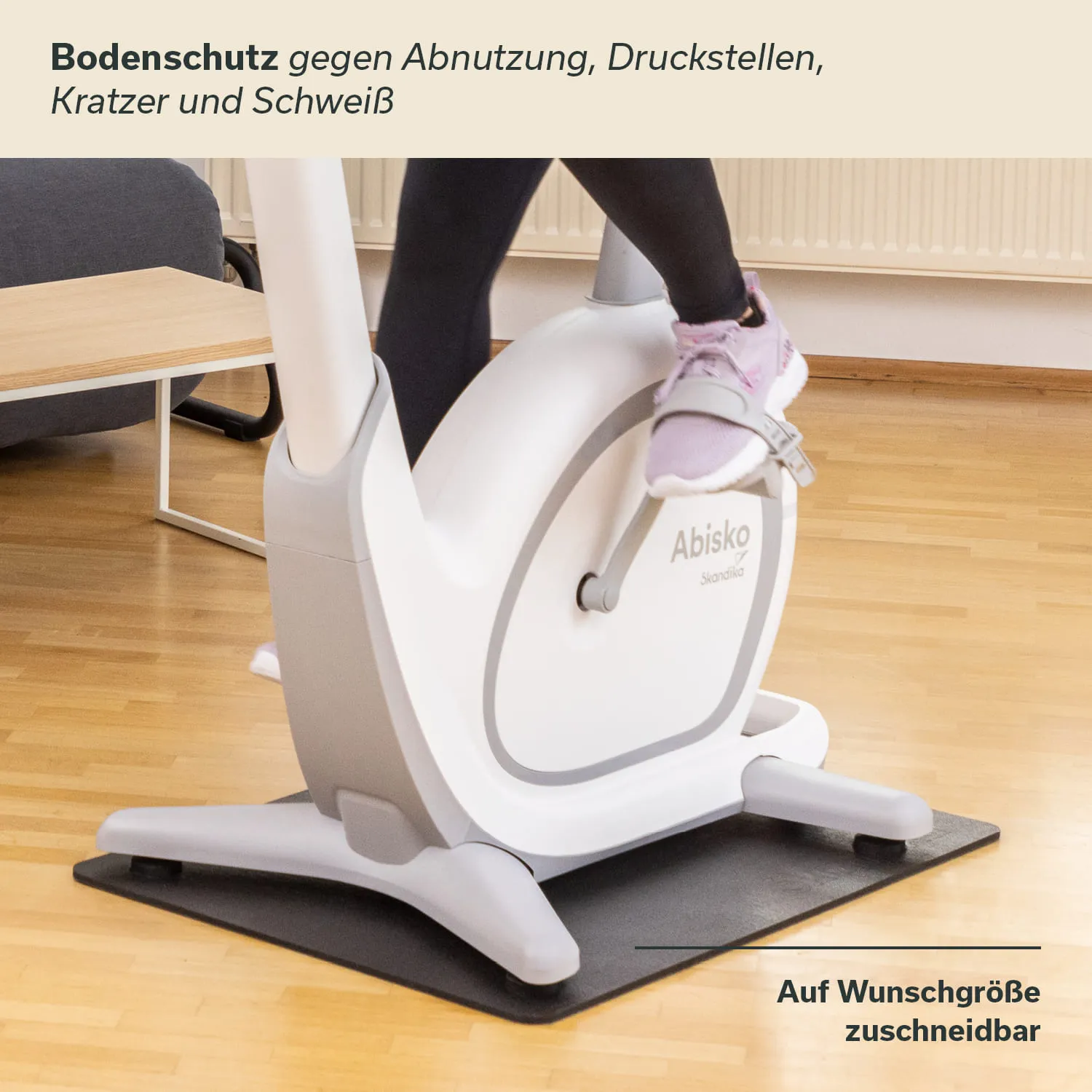 Bodenschutzmatte unter einem Fitnessgerät, Teppichboden, Fuß einer Person auf dem Gerät, neutraler Hintergrund.