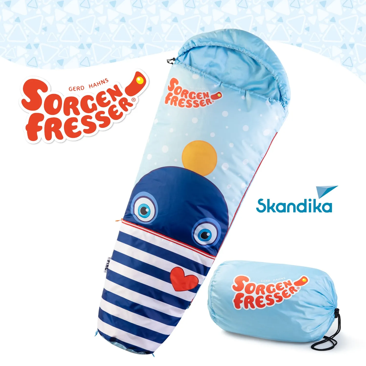 Schlafsack mit einem blauen und weißen Design, auf dem ein freundliches Tiergesicht und ein Herz abgebildet sind. Neben dem Schlafsack ist ein aufgerollter Sack mit dem gleichen Design sichtbar. Logos von „Sorgenfresser“ und „Skandika“ sind zu sehen.