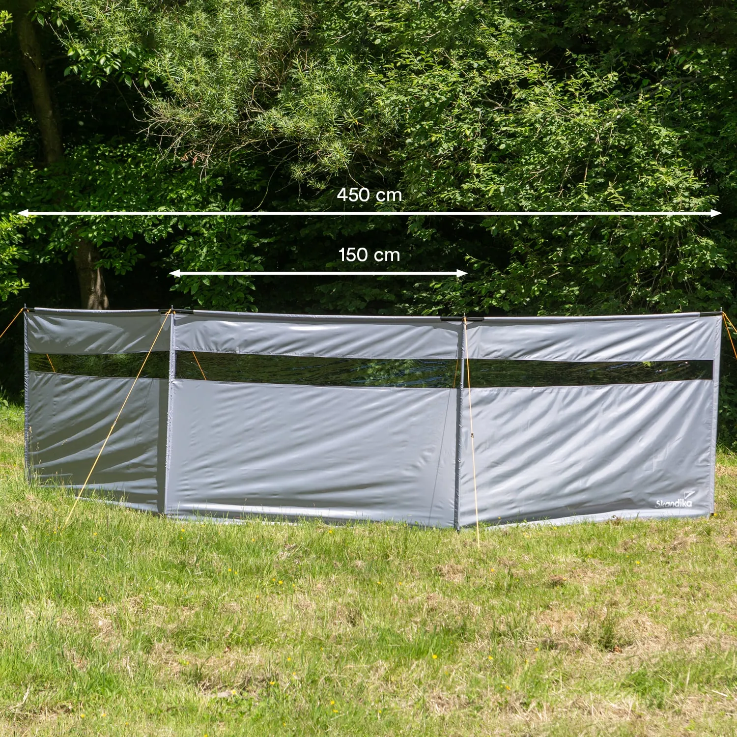 Ein grauer Sichtschutz ist auf einer Wiese aufgestellt. Er hat eine Länge von 450 cm und eine Höhe von 150 cm.