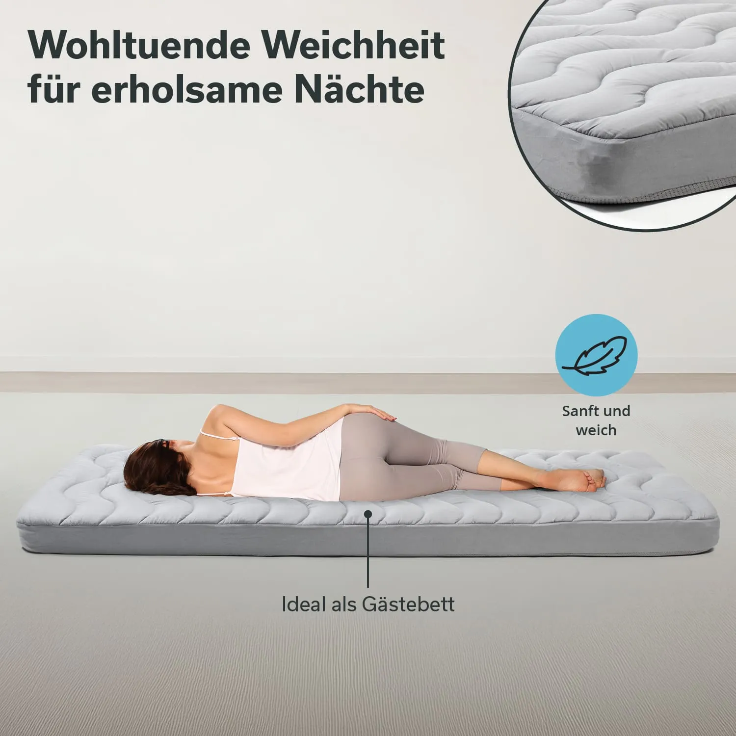 Matratze in Grauton auf dem Boden, Person liegend in bequemer Position. Text oben beschreibt Weichheit und Eignung als Gästebett.