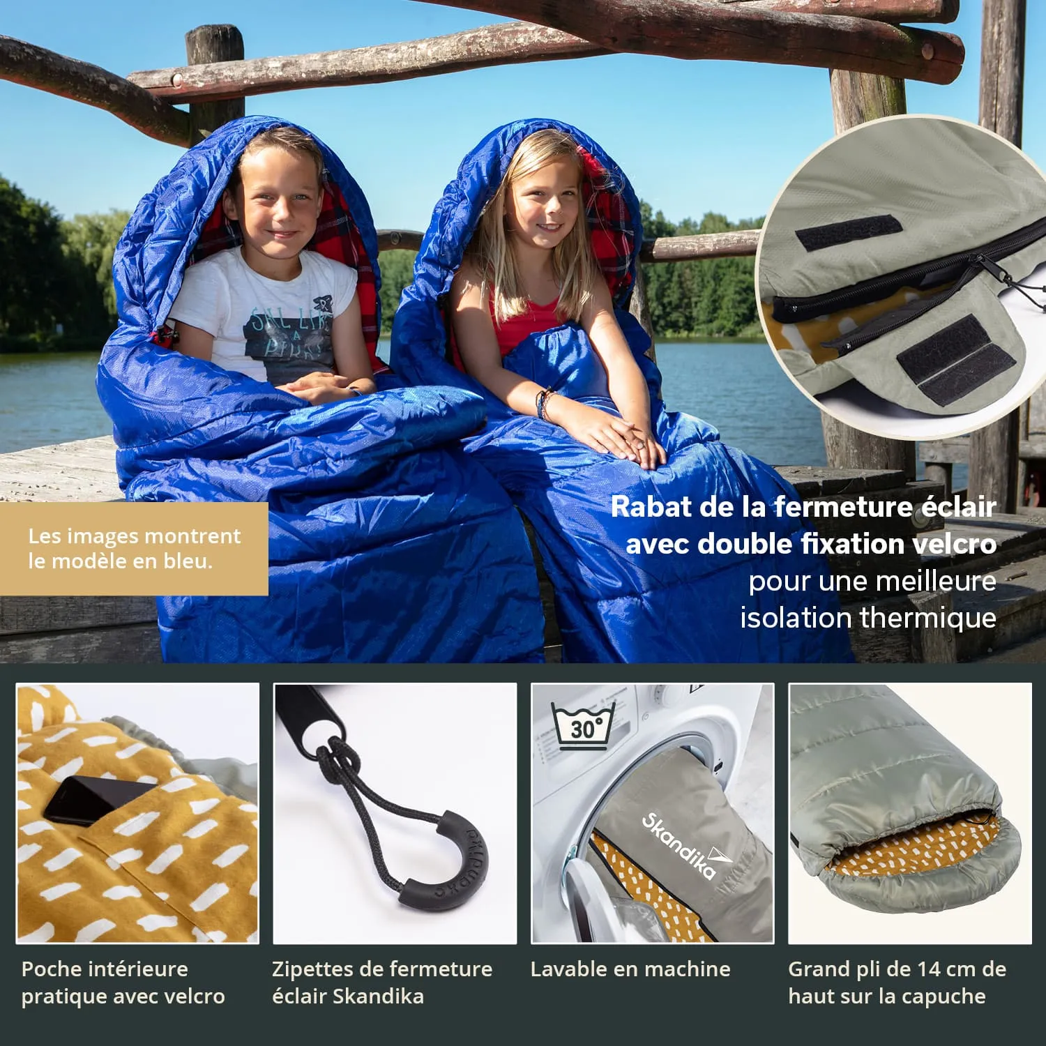 Zwei Personen sitzen in blauen Schlafsäcken auf einem Holzsteg am Wasser. Im Hintergrund sind Bäume zu sehen.