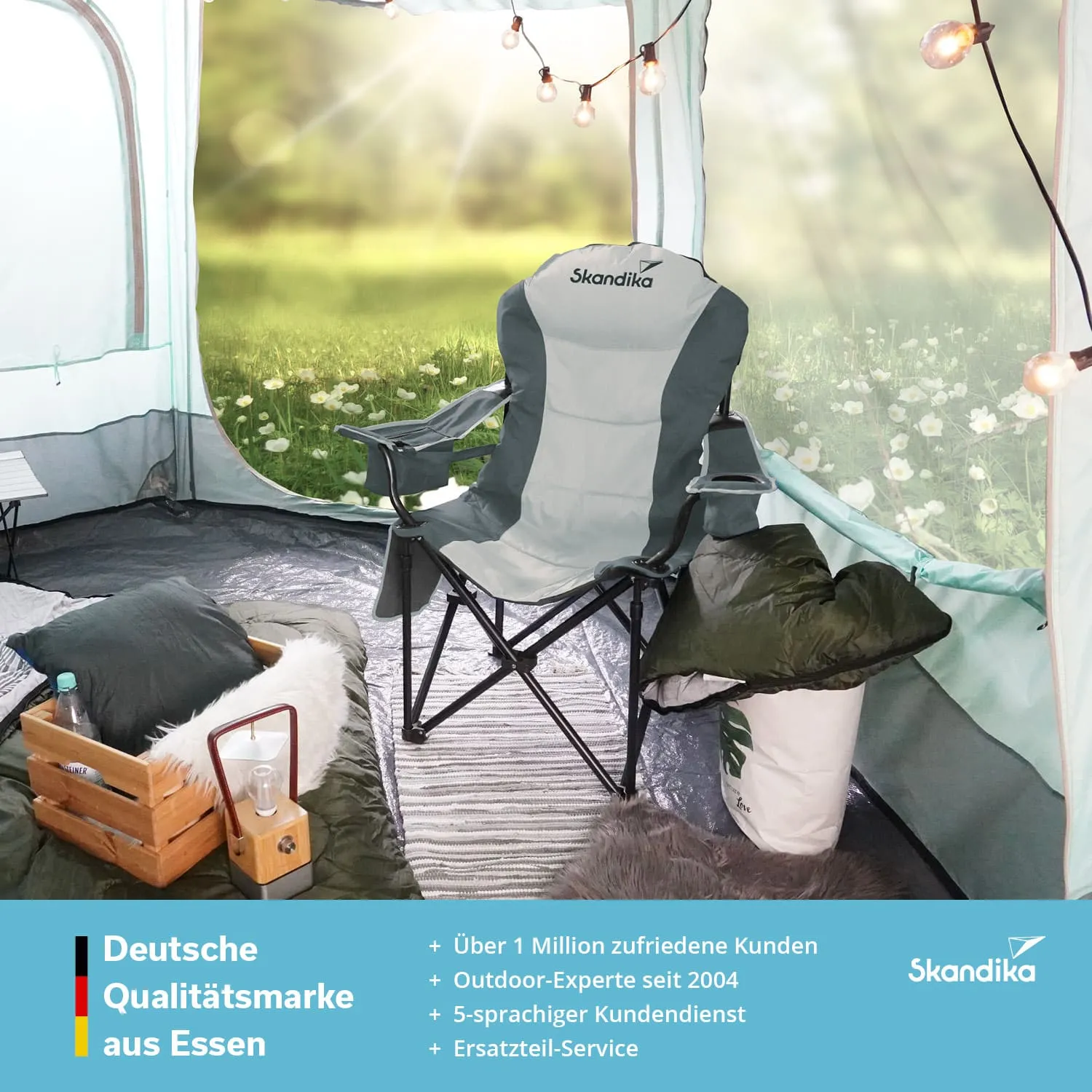 Campingstuhl in einem Zelt, umgeben von Kissen, einer Holzbox und einer Flasche. Außen sieht man eine Wiese.
