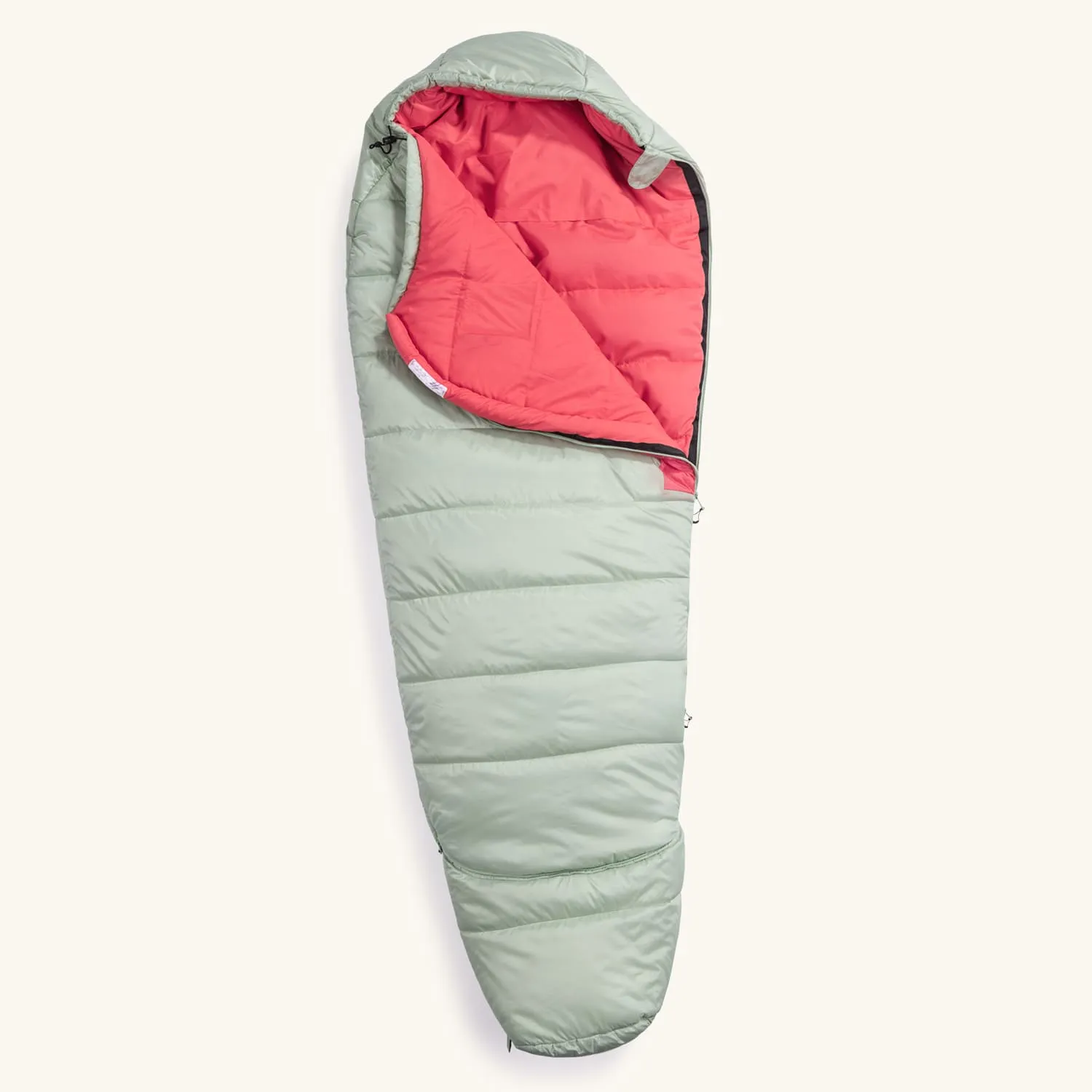 Schlafsack in Grüntönen mit rotem Innenfutter, teilweise geöffnet, auf hellem Hintergrund.
