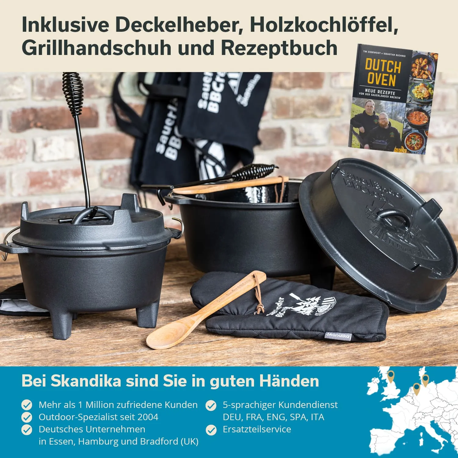 Zwei gusseiserne Töpfe, ein Deckelheber, ein Holzlöffel, ein Grillhandschuh und ein Rezeptbuch auf einem Tisch.
