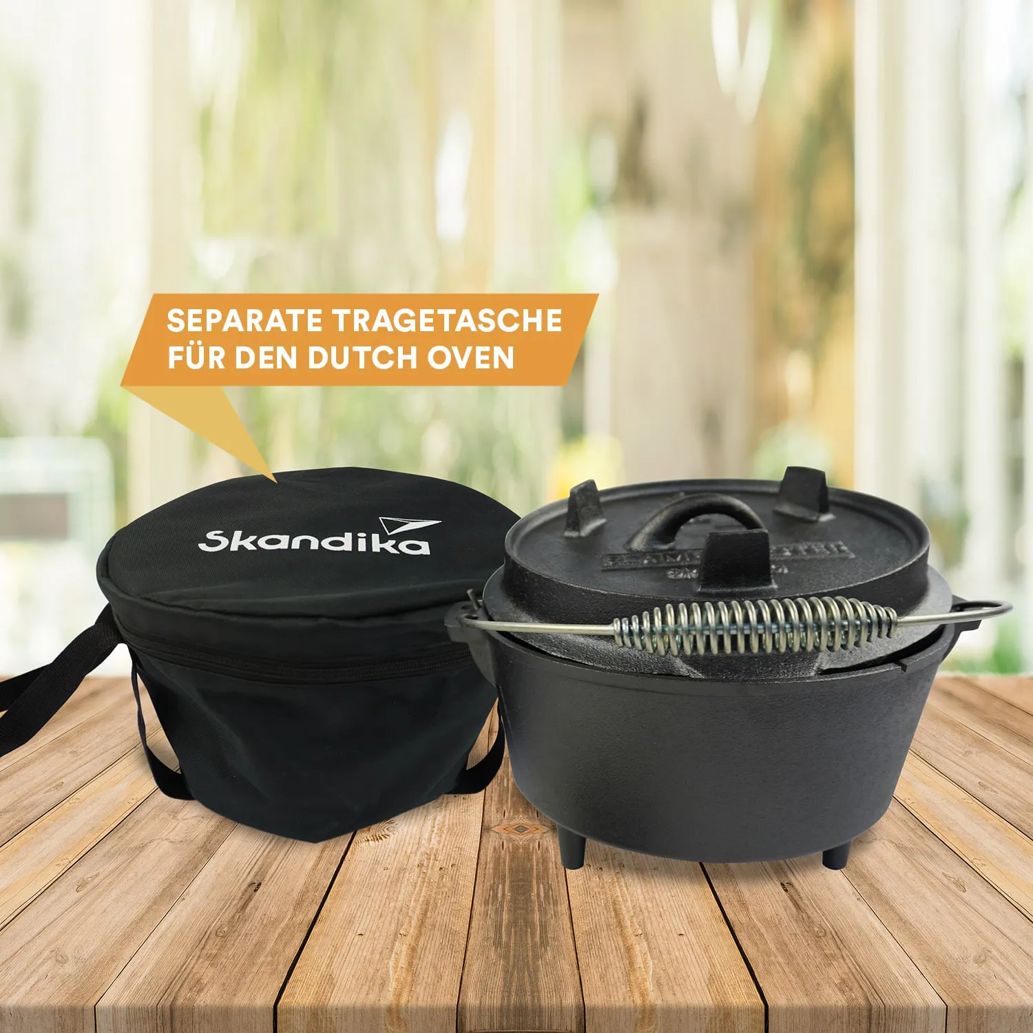 Schwarze Tragetasche mit Logo und ein Dutch Oven aus Gusseisen auf einem Holztisch, im Hintergrund verschwommen.