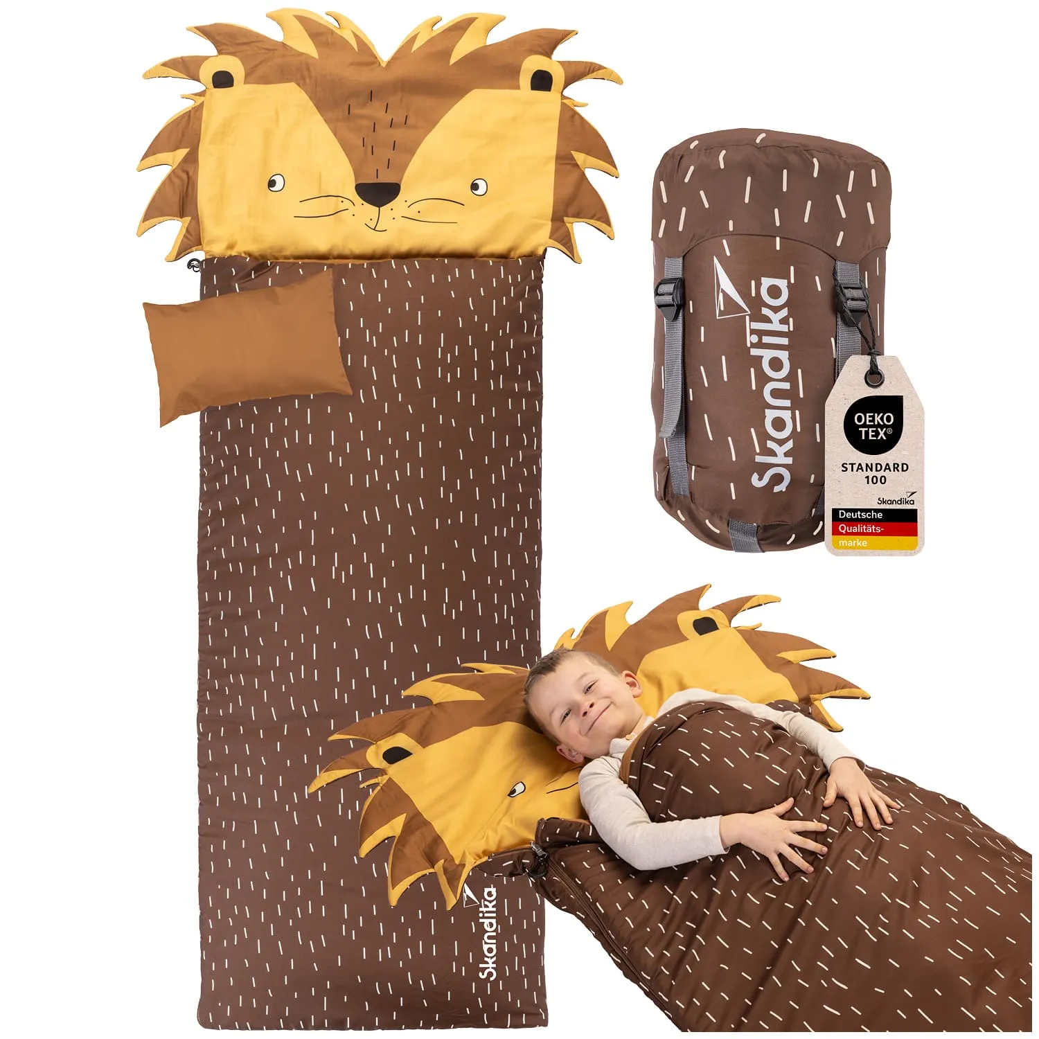 Schlafsack mit Löwen-Motiv und einer Person, die darin liegt und lächelt. Im Hintergrund eine Tragetasche.