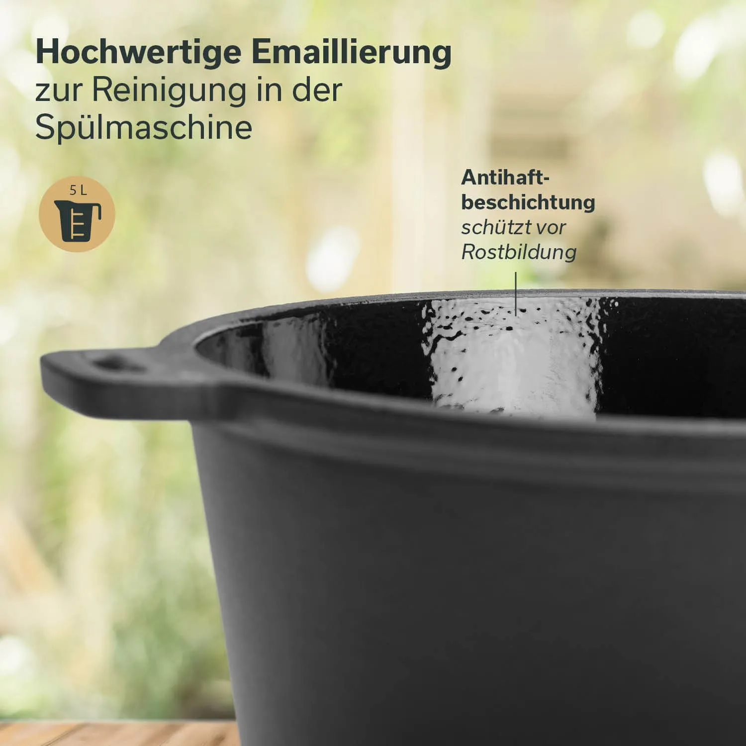Schwarzer, emaillierter Topf mit einer Füllmenge von 5 Litern auf einem Holztisch, Hintergrund unscharf.