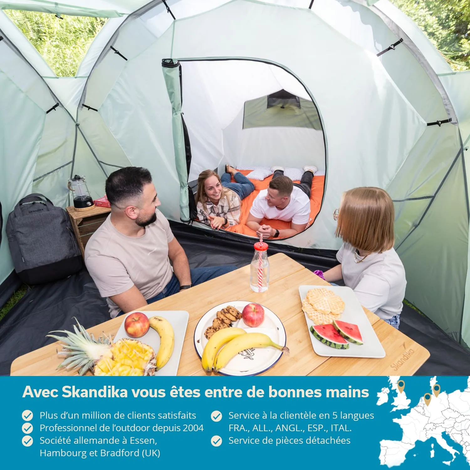 Zeltinnenansicht mit vier Personen. Ein Tisch mit Obst und Snacks. Zwei Personen liegen auf einer Schlafmatte, andere sitzen am Tisch.