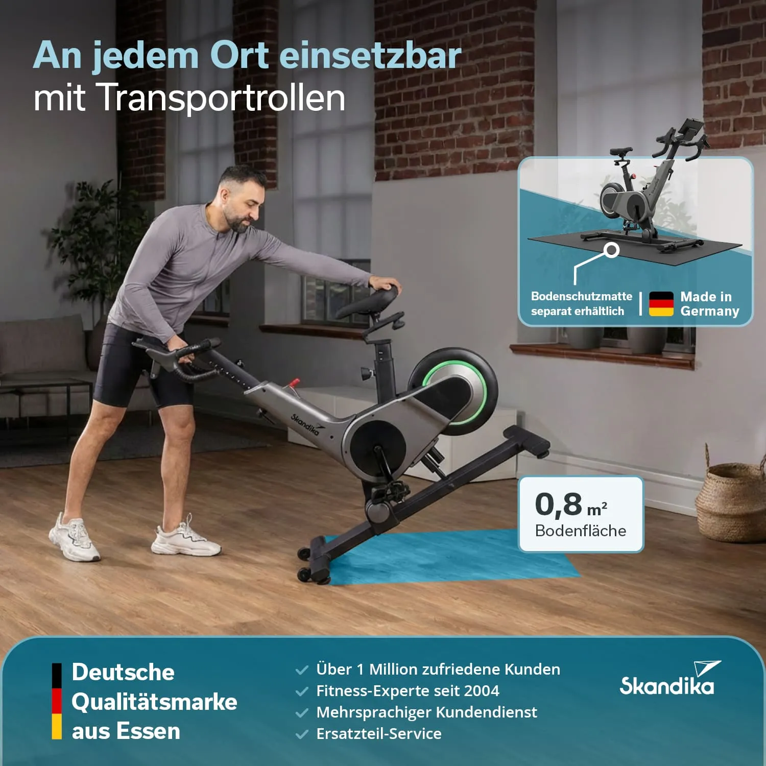 Eine Person steht neben einem Heimtrainer mit Transportrollen in einem Raum mit großen Fenstern. Im Hintergrund ist eine Couch sichtbar.