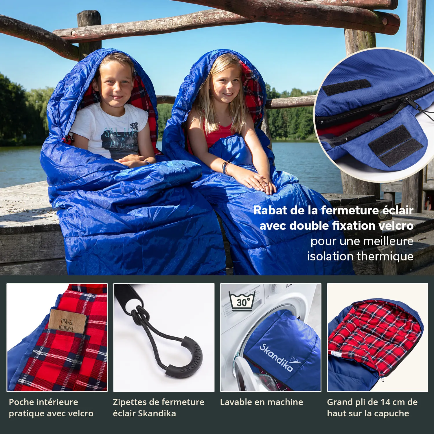 Zwei Kinder sitzen auf einem Holzsteg am Wasser, eingewickelt in blaue Schlafsäcke. Im Hintergrund Bäume.