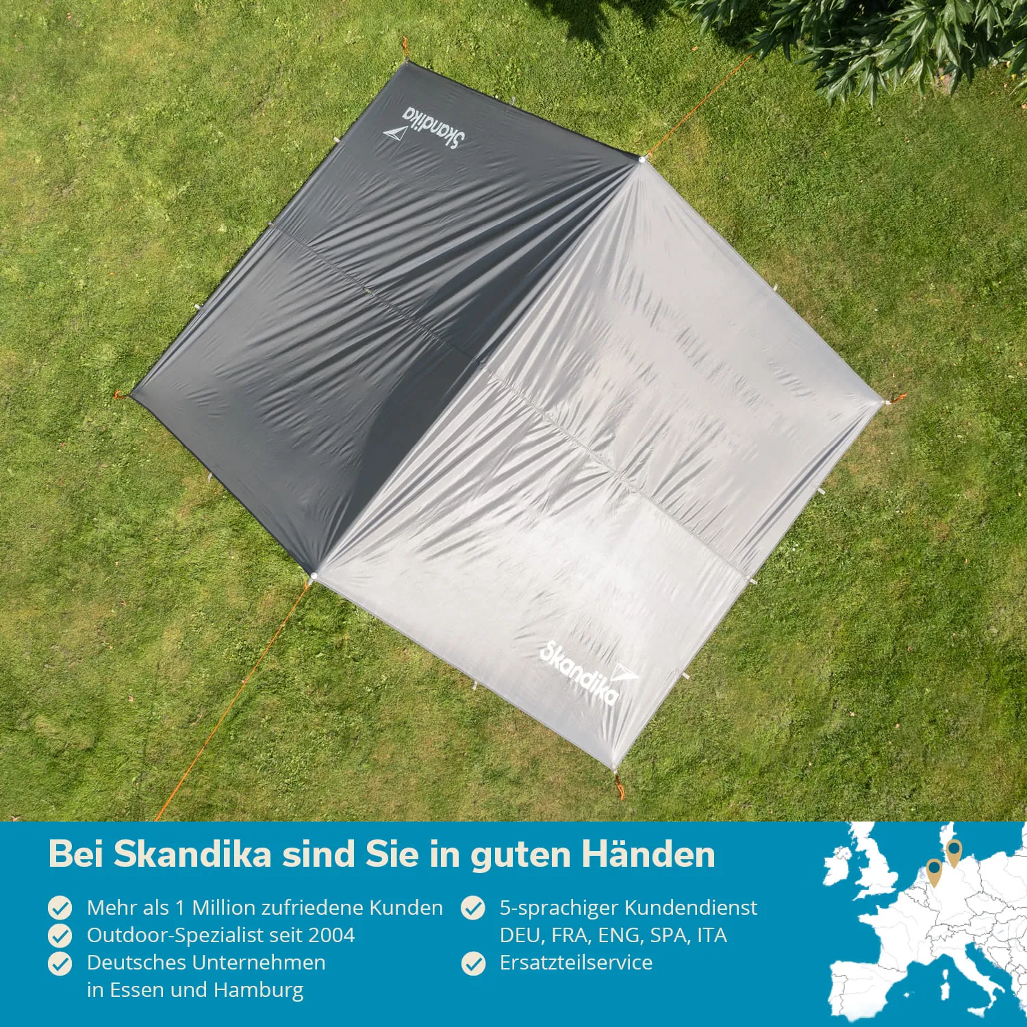 Graues Zelt oder Tarp auf grünem Gras, umgeben von Bäumen. Textinfos und Logos am unteren Bildrand.