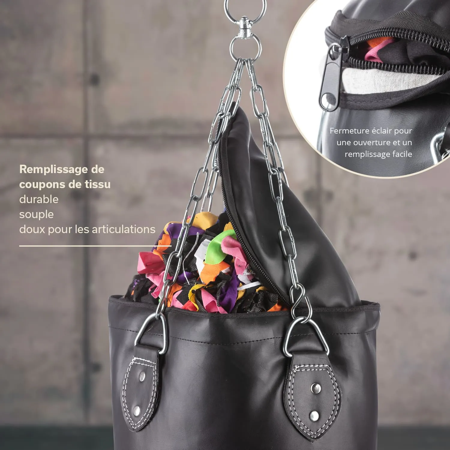 Schwarze Tasche mit Stofffüllung, oben geöffnet. Sichtbare Kettenhänger und Reißverschluss. Hintergrund unscharf und neutral.