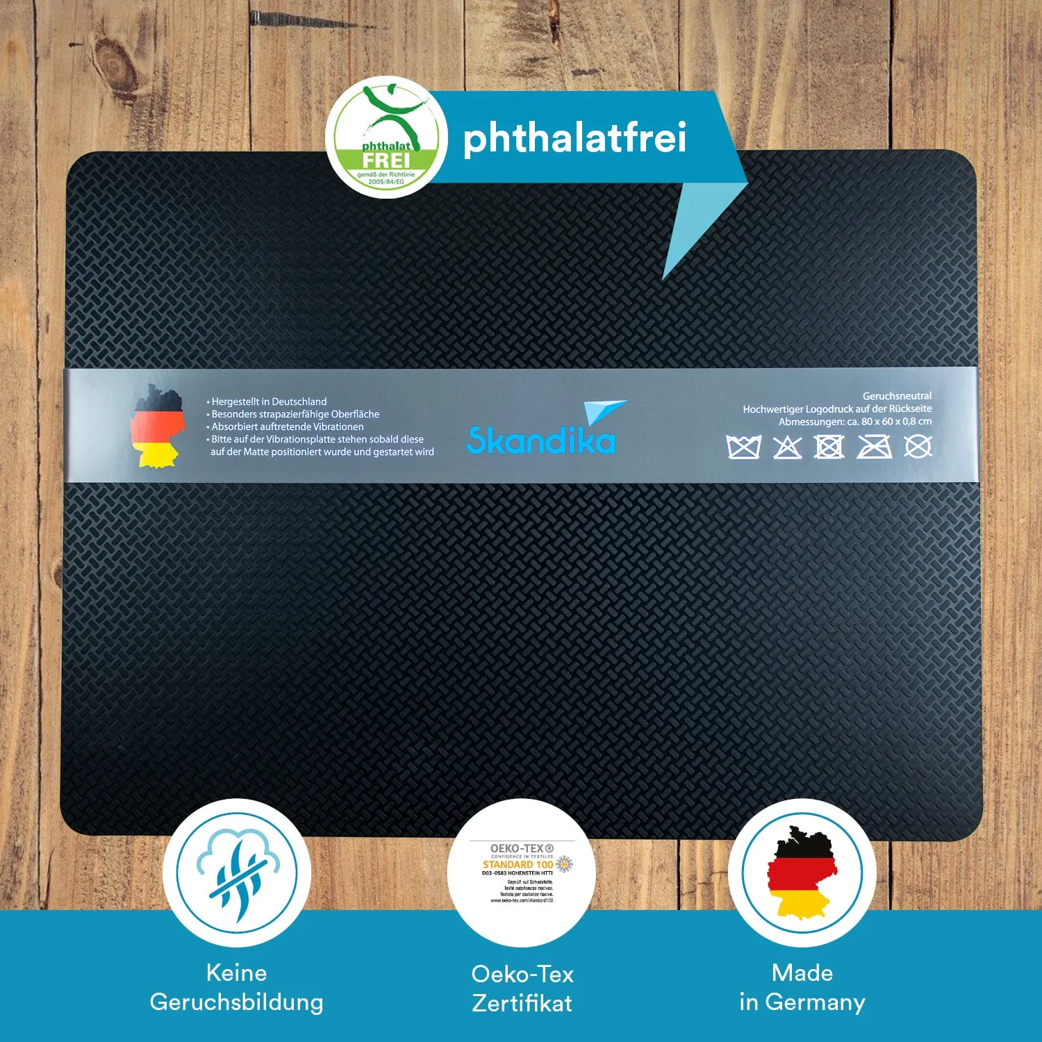 Schwarze Matte mit strukturiertem Design und grauem Aufkleber, Informationen über Material und Herkunft. Untergrund aus Holz.