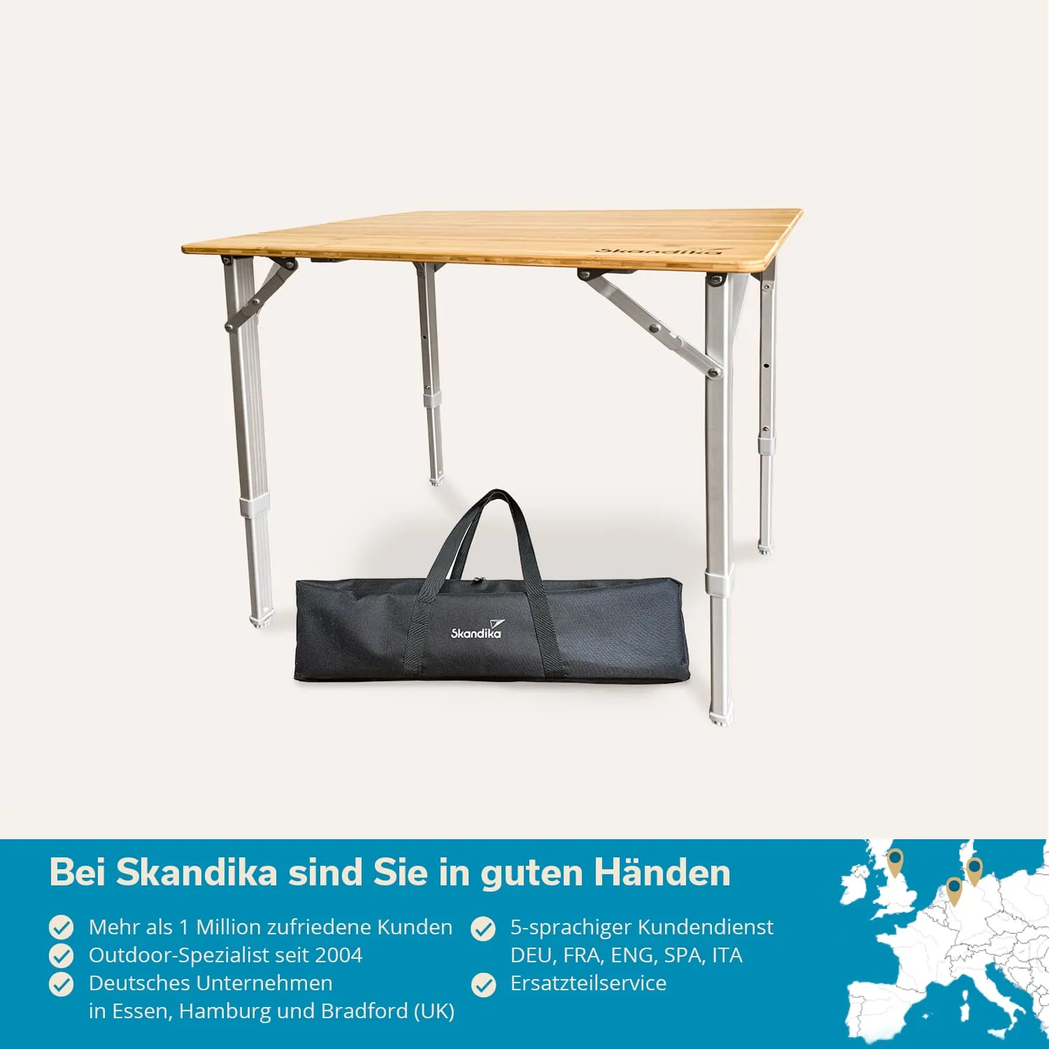 Klappbarer Tisch mit Holzplatte und Aluminiumbeinen, daneben eine schwarze Tragetasche mit dem Logo. Hintergrund hell.