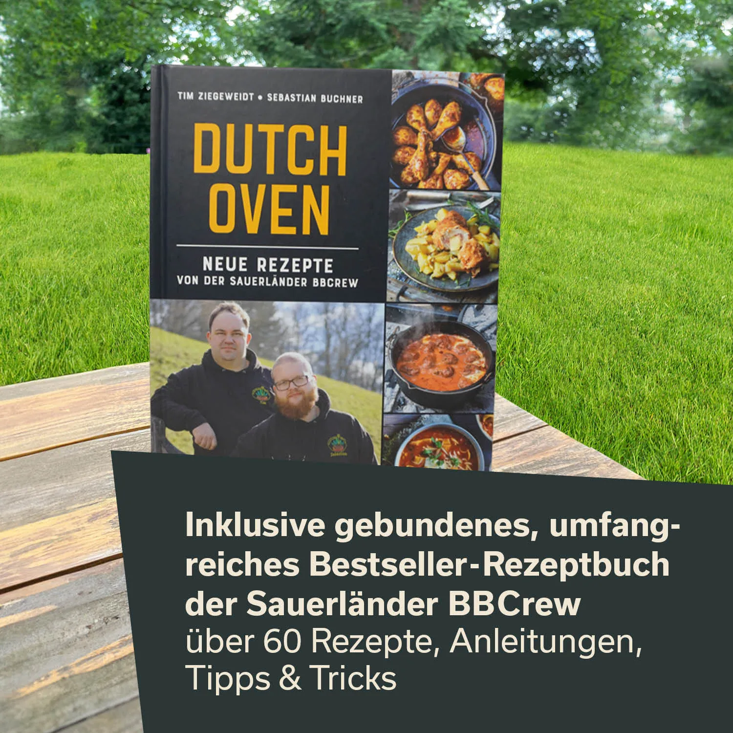 Rezeptbuch mit dem Titel "Dutch Oven", umgeben von grüner Wiese. Cover zeigt zwei Personen und verschiedene Gerichte in Töpfen.