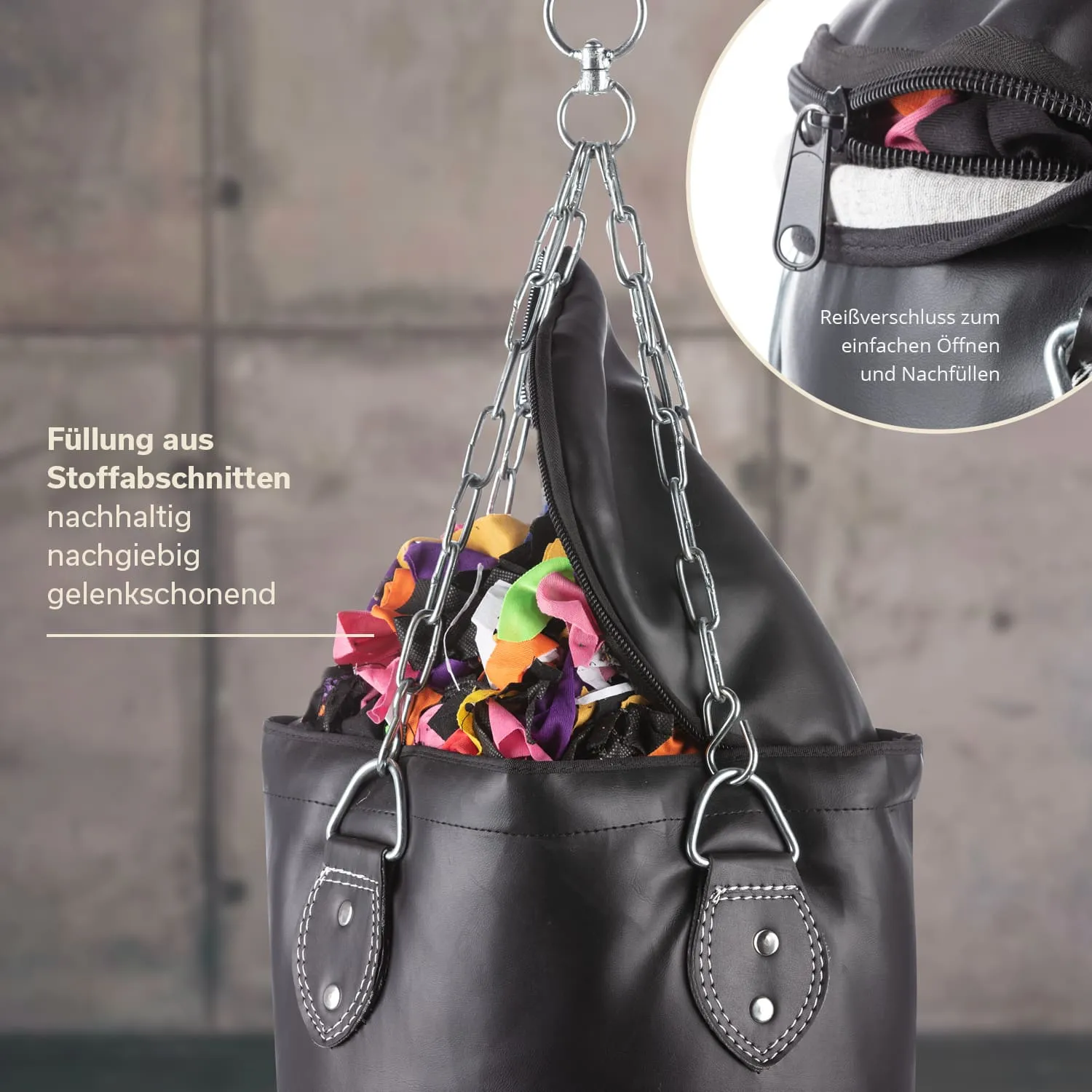 Schwarze Tasche mit Metallkette und Reißverschluss, gefüllt mit bunten Stoffabschnitten. Hintergrund ist grau.