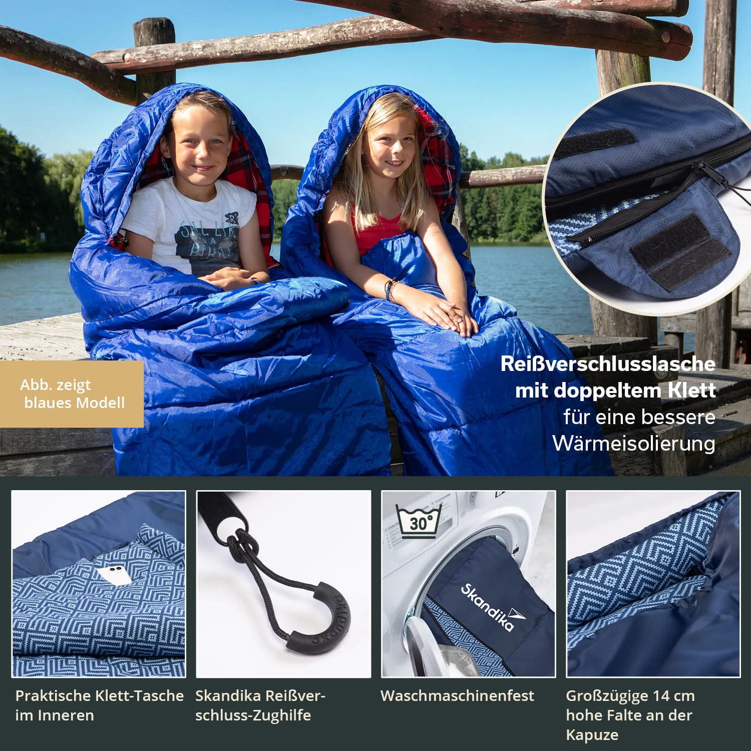 Zwei Kinder sitzen auf einer Holzplattform am Wasser in blauen Schlafsäcken.