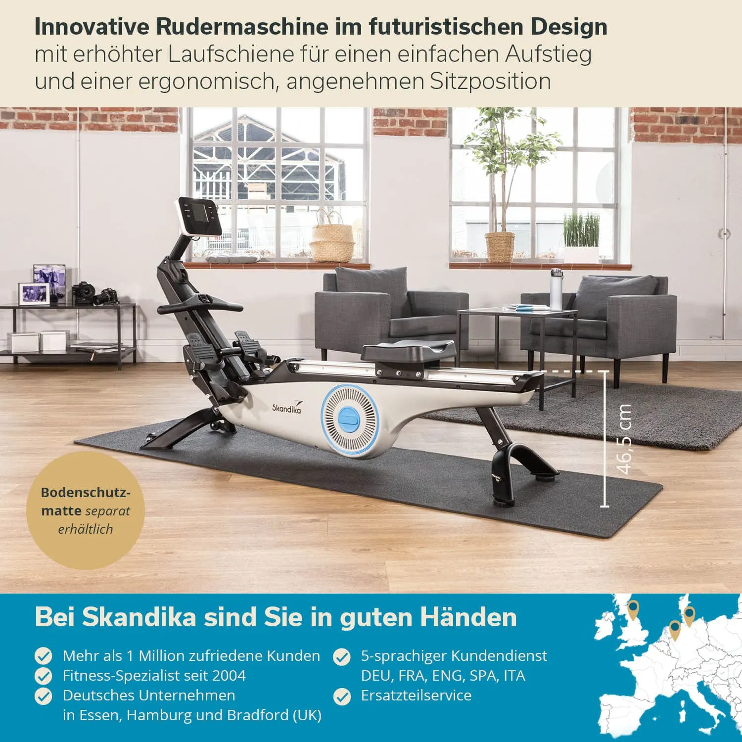 Rudermaschine in modernem Design auf einer Bodenschutzmatte, im Hintergrund eine Sitzecke mit zwei grauen Sessel.