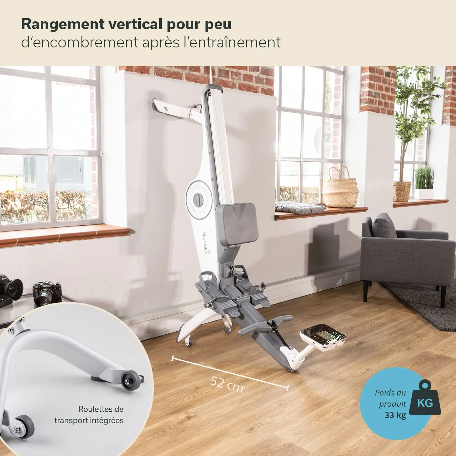 Vertikales Fitnessgerät mit grauem und weißem Design, Platz sparend in einem Raum mit Holzfußboden und großen Fenstern.