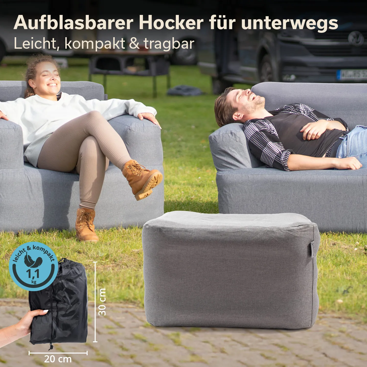 Aufblasbarer Hocker in grau auf einer Wiese, zwei Personen sitzen auf grauen Sesseln, eine Person in Boots und beigen Leggings.