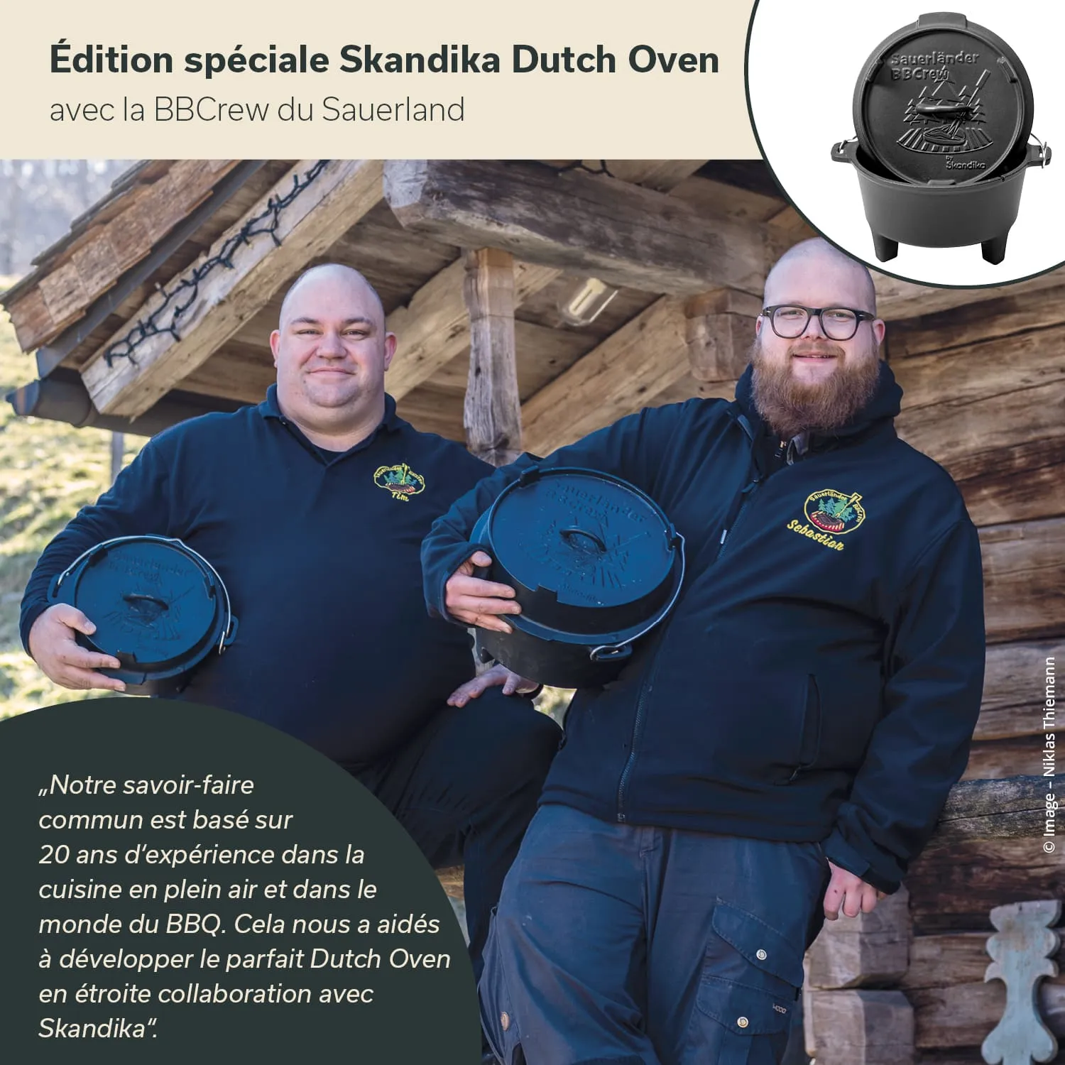 Zwei Personen stehen vor einer Holzkonstruktion und halten jeweils einen schwarzen Dutch Oven. Sie tragen schwarze Jacken mit Emblemen.