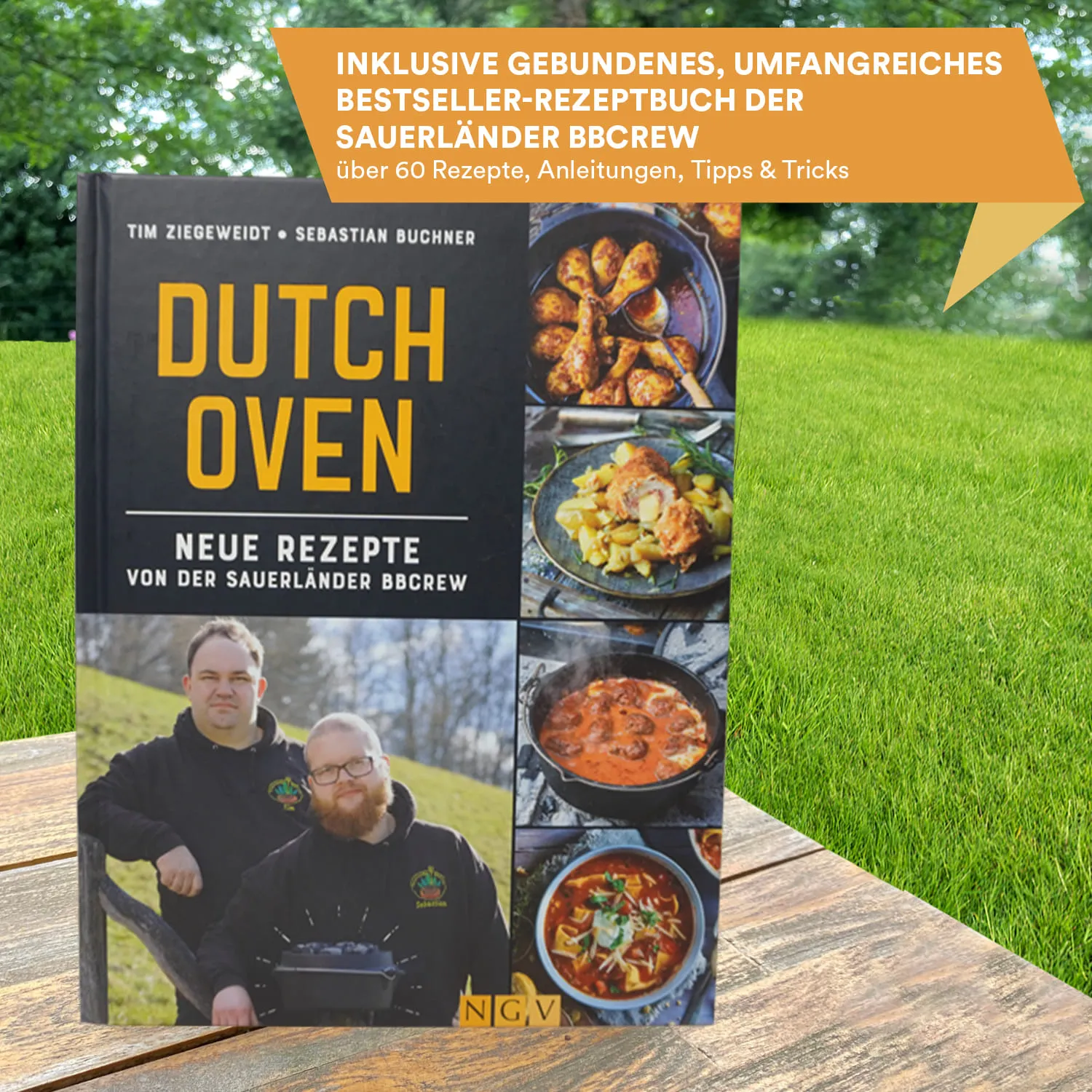 Bilderbuch mit dem Titel "Dutch Oven" auf einer Holzoberfläche, umgeben von grünem Gras. Das Cover zeigt verschiedene Gerichte und zwei Personen.