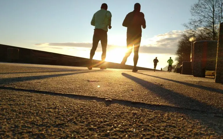 Zwei Jogger beim Sport am Morgen beim Sonnenaufgang