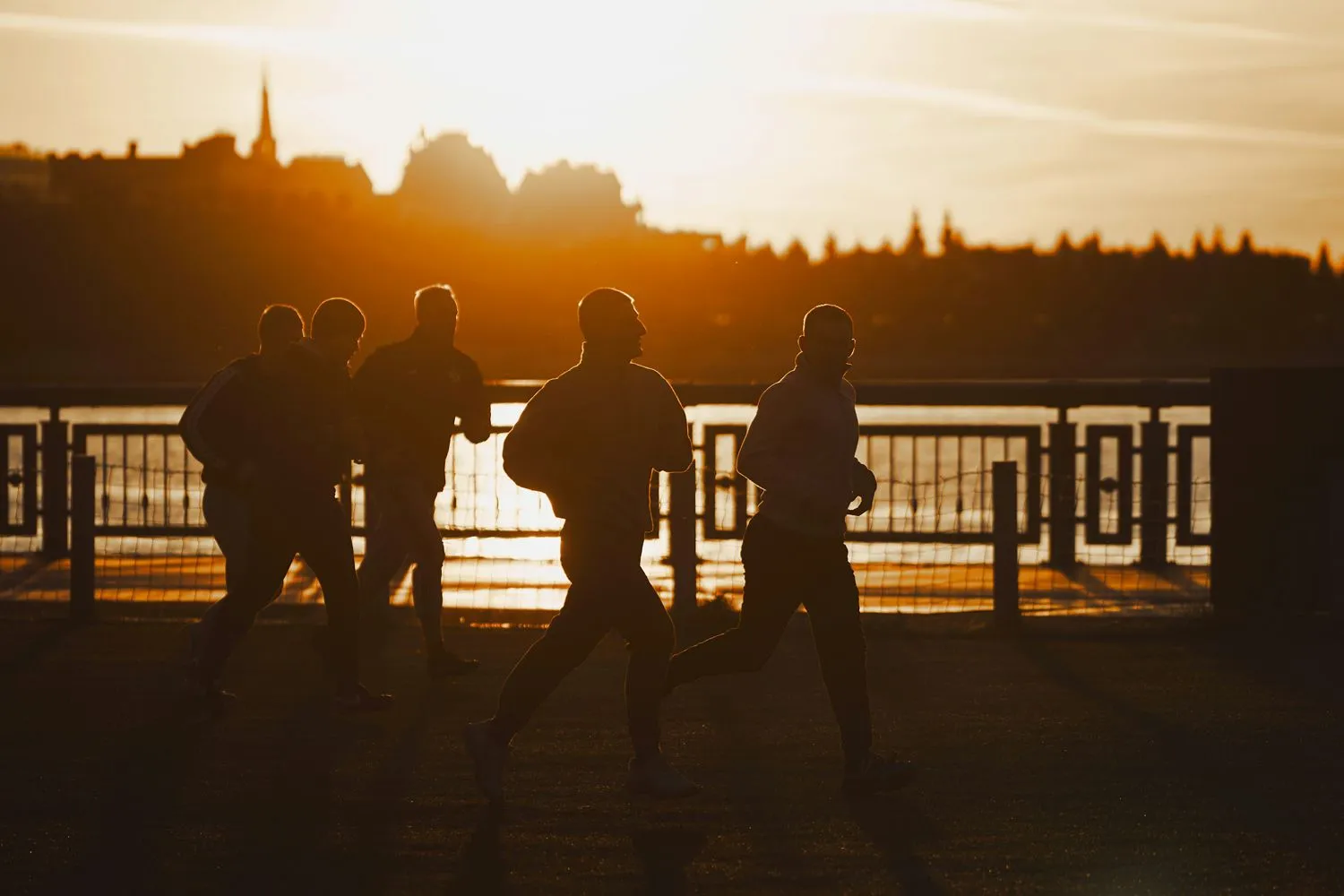 Gruppe an Läufer*innen in der Morgensonne