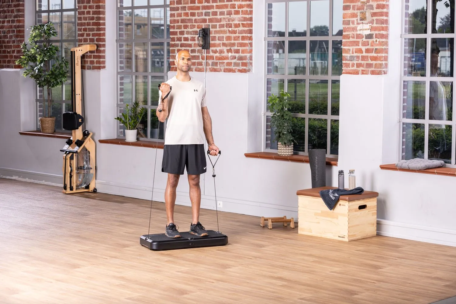 Sportler auf einer Kraftstation beim Workout mit Fitnessequipment im Hintergrund