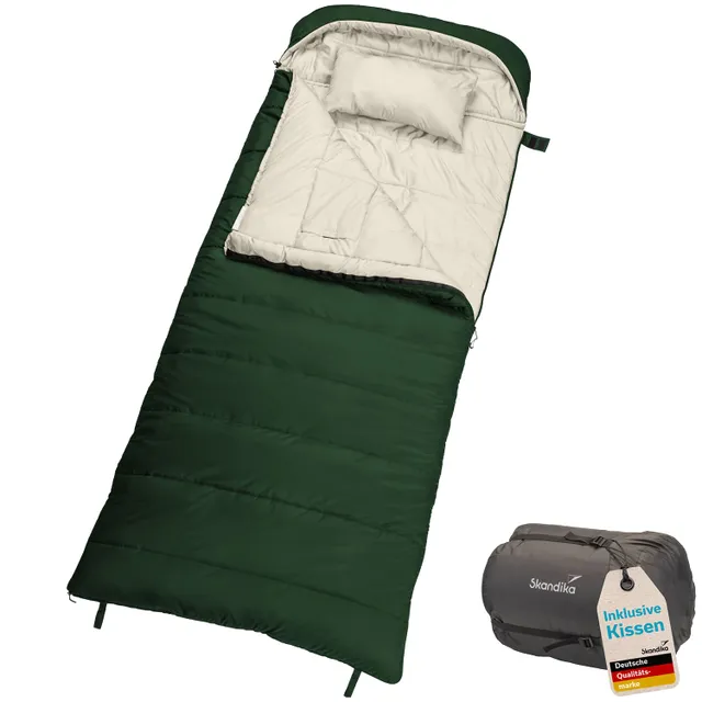 Schlafsack in dunkelgrün mit beigem Innenfutter und Kopfkissen. Neben dem Schlafsack eine zusammengepackte Variante.