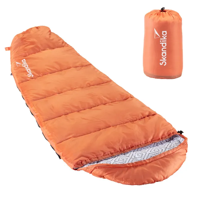 Orangenfarbener Schlafsack mit gepolsterten Kammern und gesticktem Innenfutter. Neben dem Schlafsack ist eine passende Packtasche abgebildet.