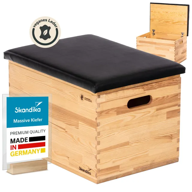 Holztruhe aus massivem Kiefernholz mit schwarzem, veganem Lederpolster. Aufklappbarer Deckel und kennzeichnendes Label.