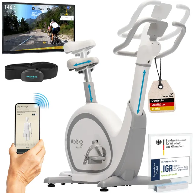 Ein stationäres Fahrrad mit verstellbarem Sattel und Lenker. Ein Bildschirm zeigt eine Radstrecke, dazu ein Smartphone mit einer App.
