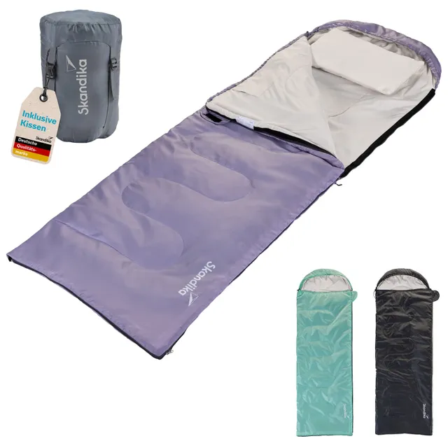 Schlafsack in lila mit integriertem Kopfkissen, umgeben von einem grauen Packbeutel und zwei weiteren Schlafsäcken in grün und schwarz.