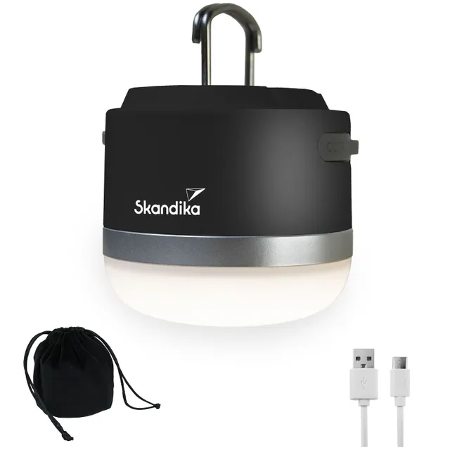 Eine tragbare Lampe in Schwarz mit silberner Unterkante, einem Karabinerhaken oben, begleitet von einem schwarzen Beutel und einem USB-Kabel.