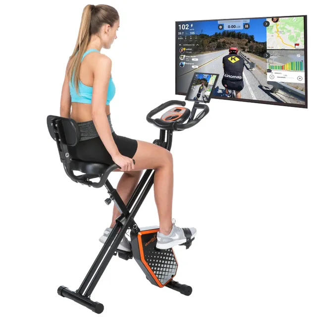 Eine Person sitzt auf einem Indoor-Fahrrad. Vor ihr ist ein Bildschirm mit einer Fahrradtour-Anzeige.